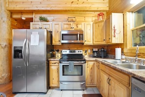A kitchen with wooden cabinets, stainless steel appliances, and a granite countertop.