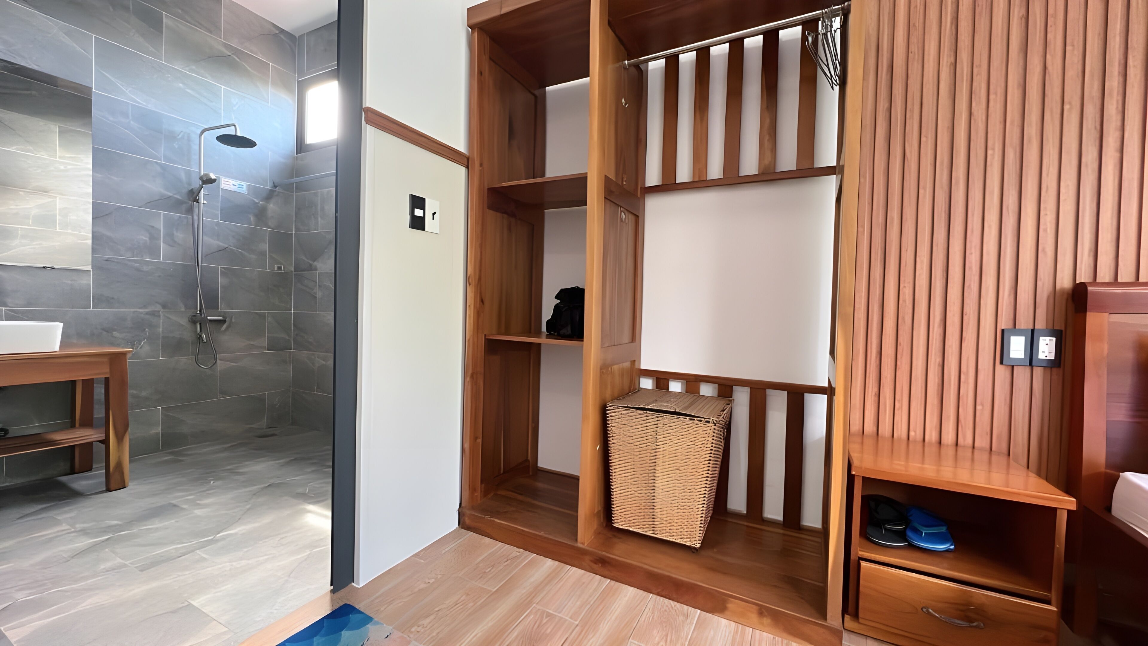 Een moderne badkamer met een douche, houten planken en een rieten mand.