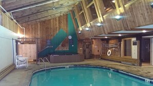 An indoor swimming pool with wooden walls and a tiled floor. - Spacious Chalet - PetFriendly/HotTub/Firepit/GameRoom/AC (Wilmington)