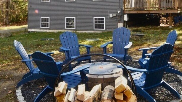 A two-story house with a deck, surrounded by trees. - Spacious Chalet - PetFriendly/HotTub/Firepit/GameRoom/AC (Wilmington)