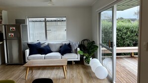 Ein modernes Wohnzimmer mit einer Couch, einem Couchtisch und einem großen Fenster.