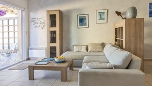 A living room with a sofa, a coffee table with a bowl of fruit, and a cabinet. - Casa Azul Turquesa (Lumio)