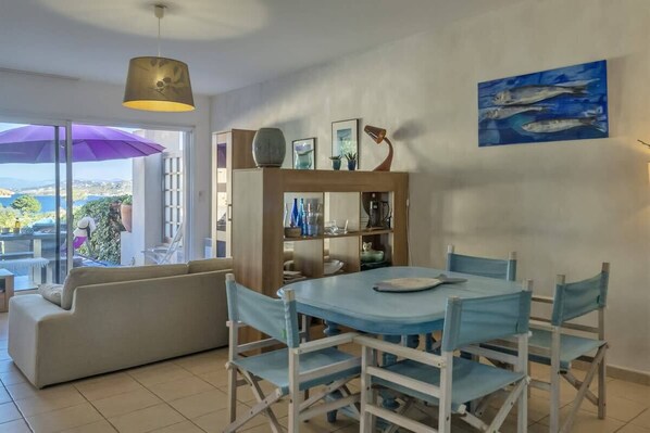 A dining area with a round table and chairs, a sofa, and a bookshelf. - Casa Azul Turquesa (Lumio)