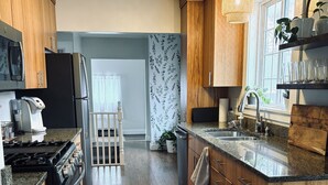 Una cocina moderna con armarios de madera, encimera de granito, estufa y refrigerador.