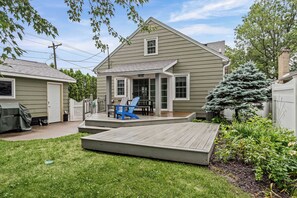 A residential property with a covered patio, a lawn, and a small deck. - King Beds | Fenced Yard | Near Downtown (La Crosse)