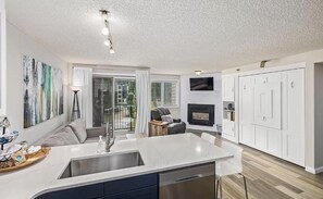 Een moderne keuken met een centraal eiland, witte keukenkastjes en een ingebouwde kookplaat.