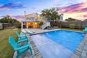 Ein zweistöckiges Haus mit Pool, Außenbereich und einer Holzterrasse.