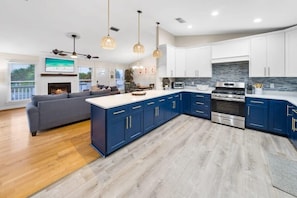 Eine moderne Küche mit blauen Schränken, einer zentralen Kochinsel und einem eingebauten Backofen.