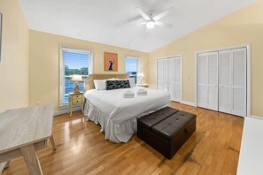A bedroom with a bed, bedside tables, a bench, a ceiling fan, and closets. - Bid-A-Wee Beach Home-Private Pool (Panama City Beach)