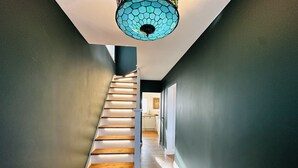 En trappe med trætrapper og en moderne lampe over sig.
