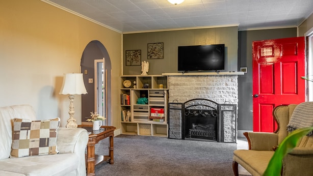 Una sala de estar con chimenea, televisión y una puerta roja.