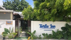 The exterior of Turtle Inn with a white wall and a signboard. - Turtle Inn Dharavandhoo (Dharavandhoo)