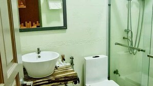 A bathroom with a white sink, toilet, and glass shower enclosure. - Turtle Inn Dharavandhoo (Dharavandhoo)