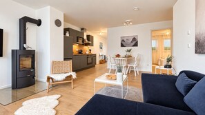 A modern living room with a sofa, a white furry rug, and a black fireplace. - Luxuriöse Ferienwohnung im Stadtzentrum: 3 Zimmer, Balkon und Infrarotkabine für Max. 5 Personen - (Winterberg)