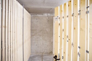 Een hal met kasten aan beide kanten, een betonnen muur in het midden en een deur met de aanduiding '2.0.1'.