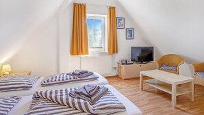 A room with two beds, a TV, a small table, and a chair. - Haus 99 - Seepark Burhave by Interhome (Burhave)