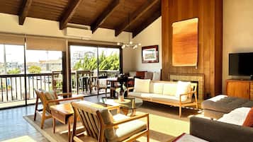 TV connectée, cheminée, livres, écrans d'ordinateur