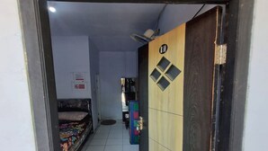 A narrow hallway with a bed on the left and a wardrobe with a 'R10' sign on the right. - Hotel O New Asembagus 3 (Asembagus)