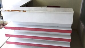 A white reception desk with red accents and three arched windows above it. - Hotel O New Asembagus 3 (Asembagus)