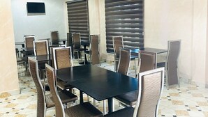 A conference room with a large table and chairs, air conditioning units, and a flat-screen TV on the wall. - Davina hill resorts and hotel  (Abuja)