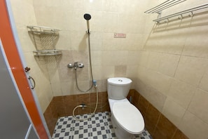 A small bathroom with a toilet, a shower, and a checkered floor. - Hotel O California (Batam)
