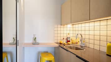 A kitchen with a sink, countertop, and stools.