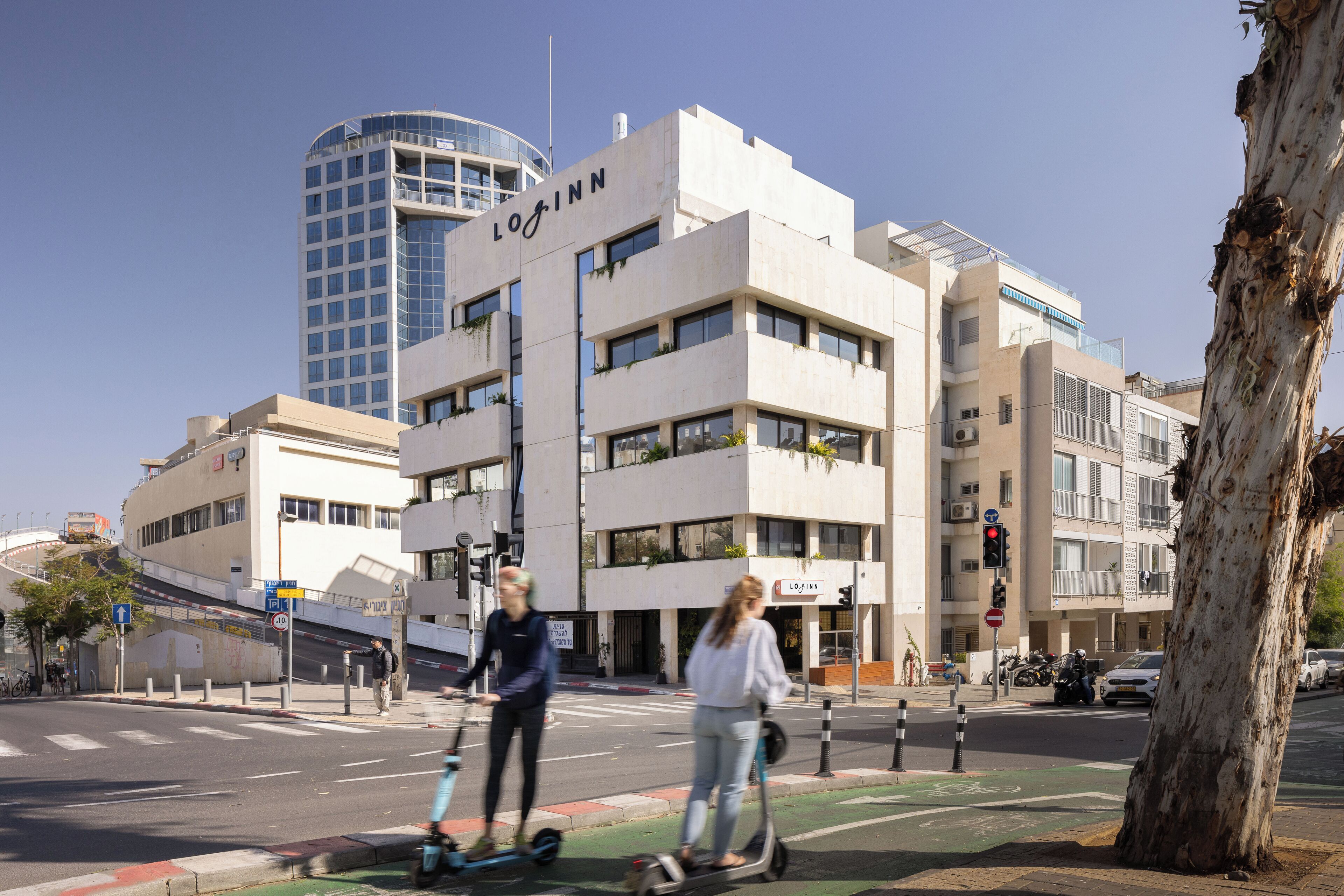 Un edificio moderno con un evidente cartello "LogInn", caratterizzato da uno stile architettonico pulito, diversi piani e ampie finestre.