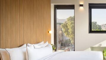 A modern bedroom with a large bed, wooden panel wall, and a view through a glass door.