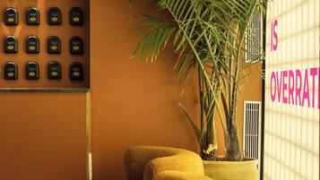 A room with a wall-mounted keycard system, a large potted plant, and a sign with partially visible text.