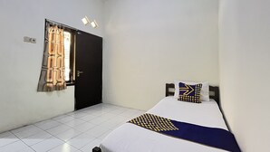 A small, clean room with a single bed, a window with curtains, and a door. - OYO Life 93398 Sudimoro Guest House Syariah (Malang)