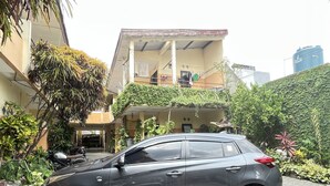 A car parked in front of a building with a balcony and greenery. - OYO Life 93398 Sudimoro Guest House Syariah (Malang)