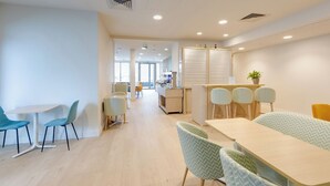 A modern meeting room with a long table, several chairs, a whiteboard, and a plant. - Brit Hotel Confort Carhaix (Carhaix-Plouguer)