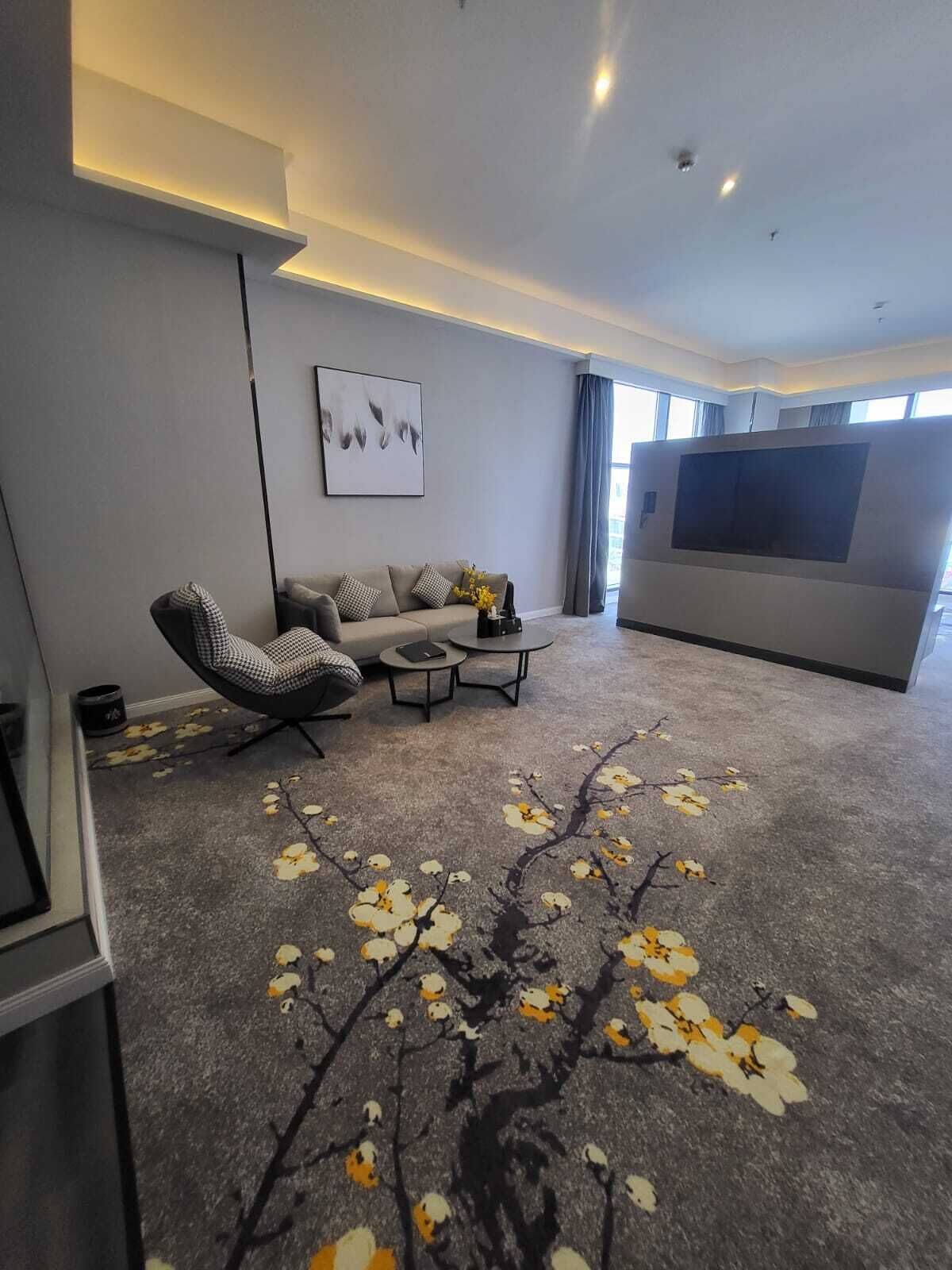 Una sala de estar moderna con un sofá, una mesa de centro y una pantalla de televisión grande.