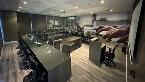 A modern conference room with a long table, multiple chairs, and a large screen. - msharef almoden hotel (Riyadh)