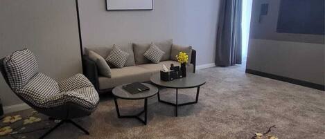 Ein modernes Wohnzimmer mit einer Couch, einem Couchtisch und einem gemusterten Teppich.