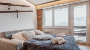 Ein Schlafzimmer mit Bett, Fenster mit Blick und Skiständer.