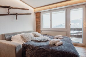 Quarto com cama, janela com vista e suporte para esquis.