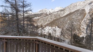A wooden deck overlooking a mountainous landscape with snow-capped peaks. - Appartement rénové avec vue panoramique et sauna (Saas-Fee)