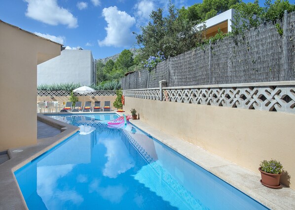 A swimming pool with lounge chairs and a wooden fence. - VILLA TONIETA - 10 MIN WALK TO THE BEACH (Pollensa)