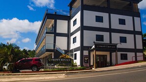 Un hôtel à plusieurs étages, sur lequel on peut lire l’inscription : « Crown Royale Hotel & Lounge ».