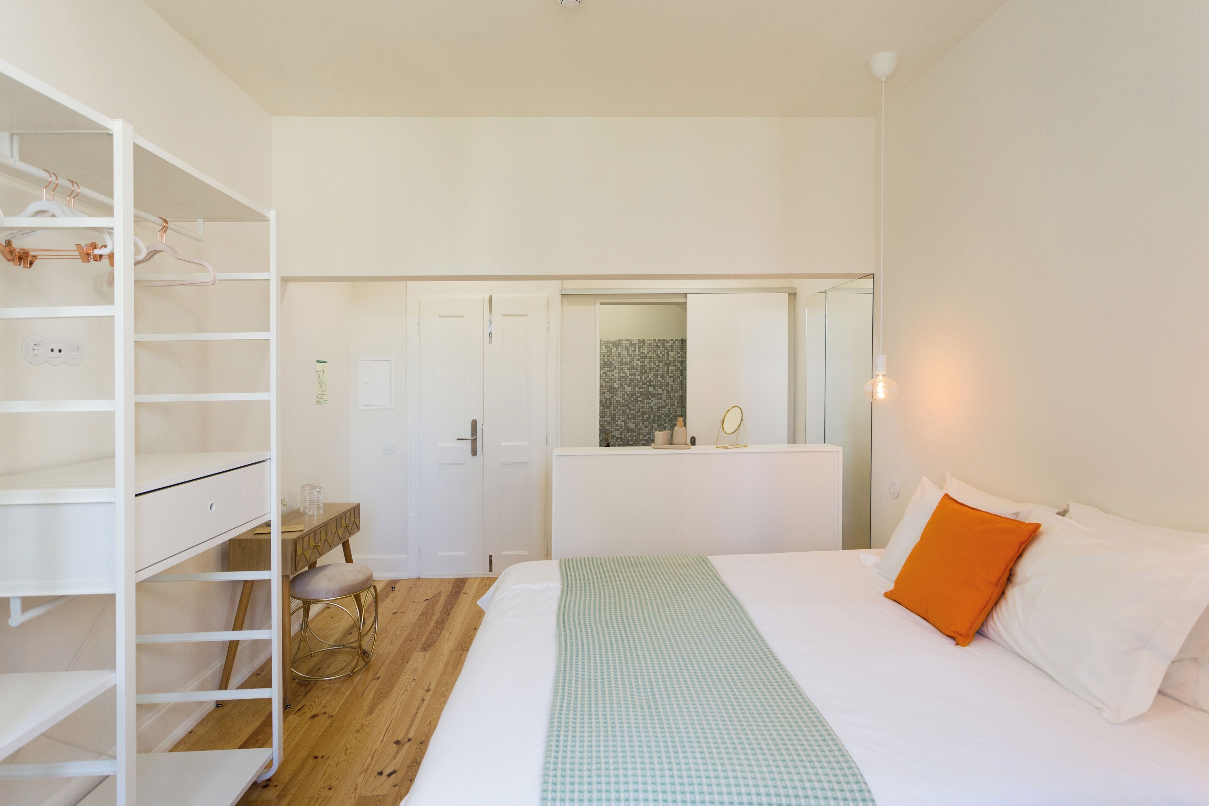 Une chambre à coucher comprenant un lit, une armoire, un bureau et un miroir.