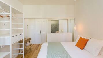 Une chambre à coucher comprenant un lit, une armoire, un bureau et un miroir.