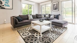 Una sala de estar moderna con un sofá modular, una mesa de centro y alfombras estampadas.