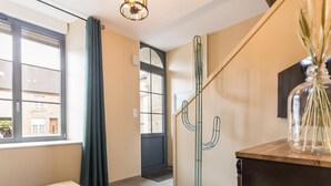 A room with a wooden table, a cactus sculpture, a glass vase with plants, and a view of a building through a window. - Cozy House with Sunny Terrace in Cuves (Cuves)