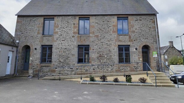 A stone building with a symmetrical facade, multiple windows, and a central entrance with steps. - Cozy House with Sunny Terrace in Cuves (Cuves)