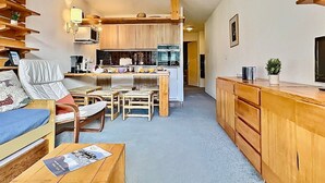 A compact living space with a kitchenette, a dining area, and a seating area with a sofa and chairs.
