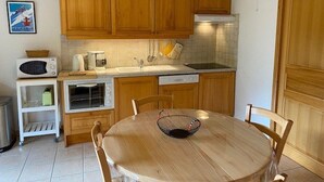 A compact kitchen with wooden cabinets, a microwave, a toaster, and a sink. - Beautiful 4-pers. apartment with balcony and garage in Grand-Bornand (Le Grand-Bornand)