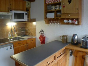 A kitchen with wooden cabinets, a microwave, a sink, and a countertop. - 2-room apartment with mezzanine, ski locker and private parking in Samoëns (Samoëns)