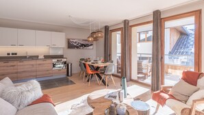 A modern apartment with a kitchen, dining area, and living room. - Charming 3-room apartment with balcony and wifi in Huez (Huez)