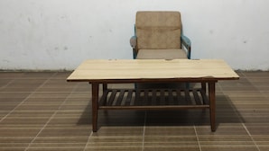 A wooden table with a slatted design, positioned in front of a chair with a patterned fabric seat against a plain wall. - Hotel O Pondok Tawing Rumbih (Tamban)